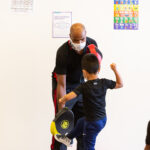 MMA teacher at new settlement teaching kid how to kick