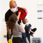 MMA teacher at new settlement teaching kid to punch