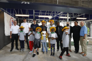 Group photo of children, Bronx community leaders and Yankees players in front of a hydroponic garden.