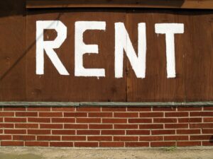 Rent is written in white paint on the outside of a building
