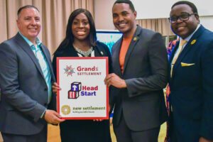 Rigaud Noel - Executive Director, Robert Cordero - CEO of Grand Street Settlement, Vanessa L. Gibson - Bronx Borough President, Ritchie Torres - Congressman, holding up a sign commemorating Head Start/Grand Street Settlement/New Settlement collaboration.